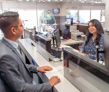 Cheerful bank teller assisting a customer