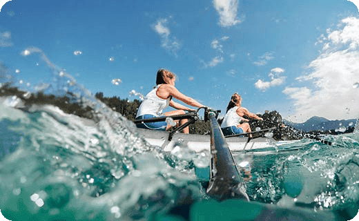 female athletes rowing across lake